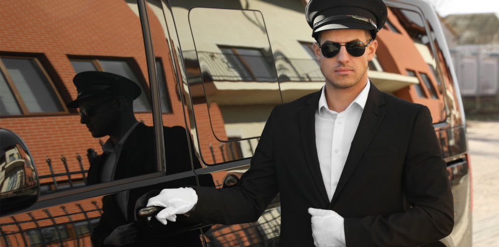 Professional private driver in Morocco standing by a black luxury car